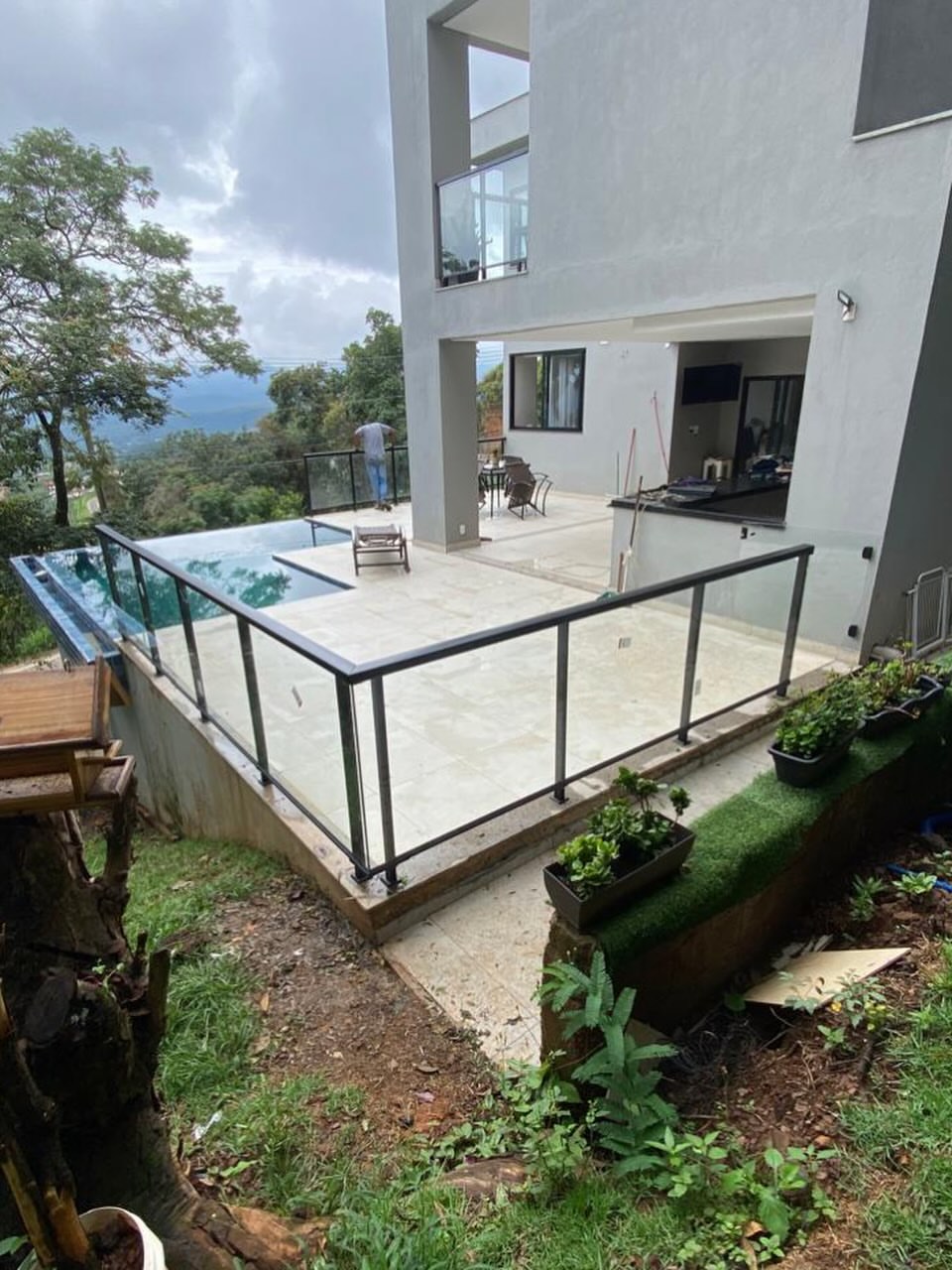 Guarda-corpo panorâmico em vidro com alumínio preto ao lado de piscina